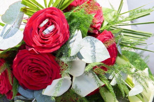 Photo gold rings on background of a bouquet of roses