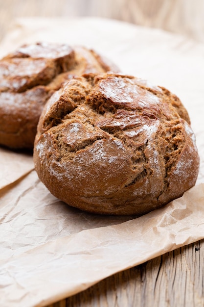 Gold rustic crusty loaves of bread and buns on wooden background Still life captured from above top view flat lay