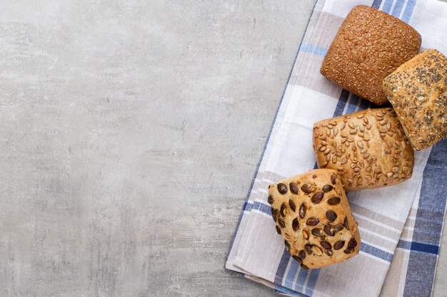 Золотые деревенские хрустящие буханки хлеба и булочки на деревянном фоне