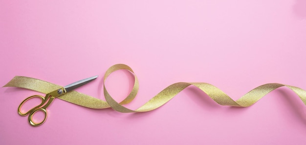 Gold scissors and golden ribbon pink background banner