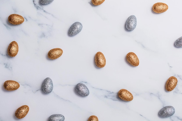 Gold and silver glitter easter eggs on a marble background