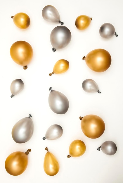 Золотые и серебряные воздушные шары для празднования вечеринки на простом фоне
