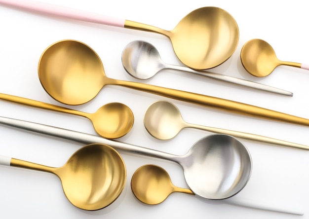 Gold and silver spoons, teaspoons on a white background