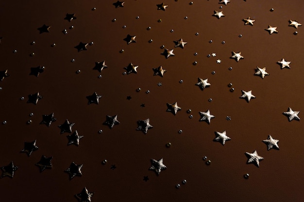 Фото Золотые блески и звезды на темном праздничном фоне конфетти с блеском сверху