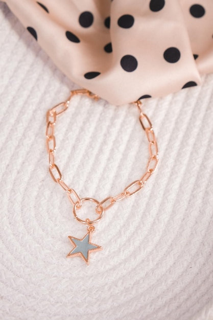 A gold star charm necklace with a gold star charm.