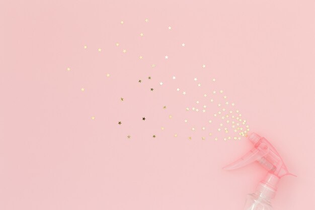 Photo gold stars confetti spraying on pink background