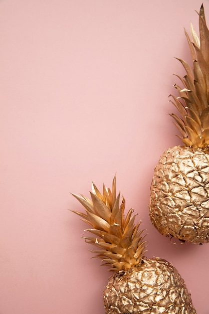 Gold tropical pineapple on a pastel pink background Flat lay summer background