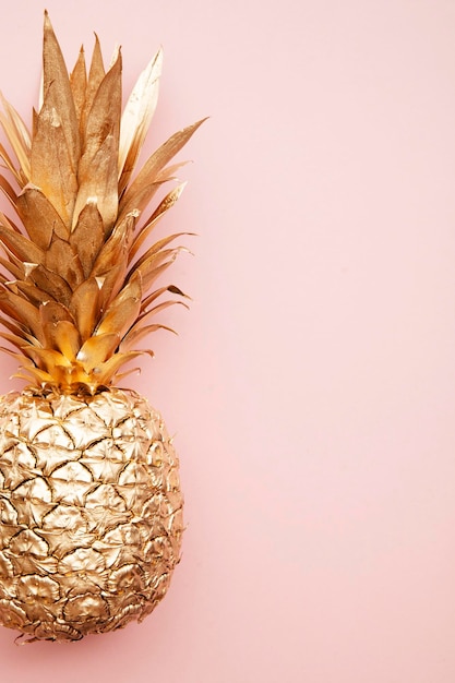 Gold tropical pineapple on a pastel pink background flat lay summer background