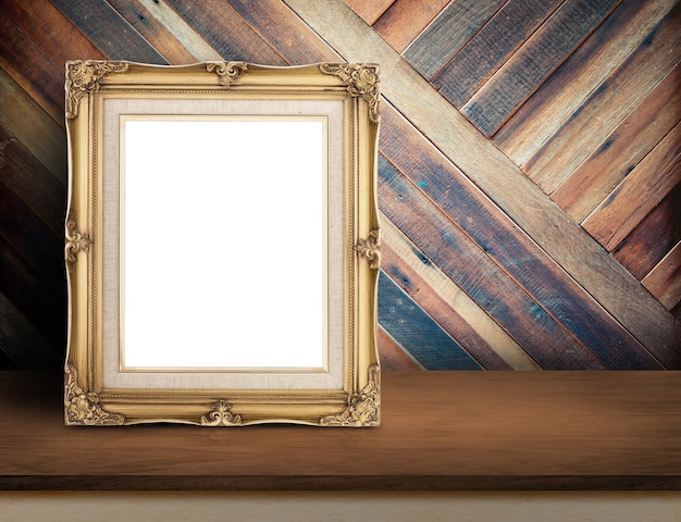 Gold victorian picture frame on wooden table top at tropical diagonal wood wall