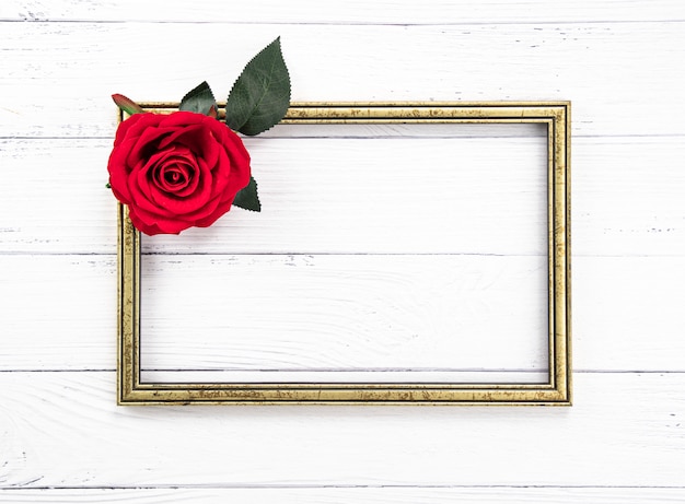 Gold vintage wooden frame and a red rose