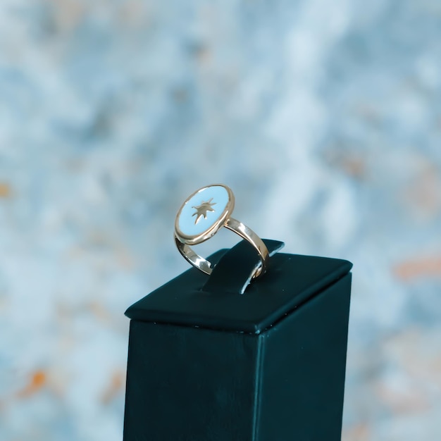 a gold watch sits on a black box with a blue background.