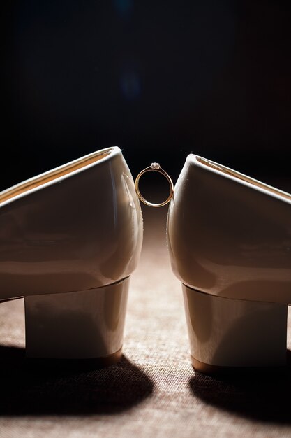 Gold wedding ring with women's shoes on the wedding day