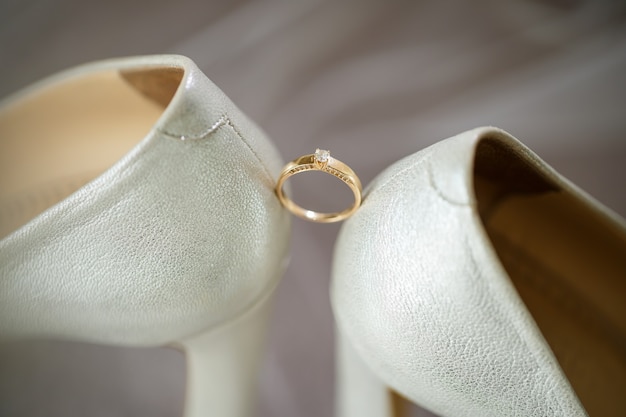 Gold wedding ring with women's shoes on the wedding day