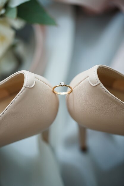 Gold wedding ring with women's shoes on the wedding day