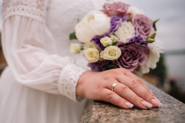 Gold wedding rings are on the bride's hand