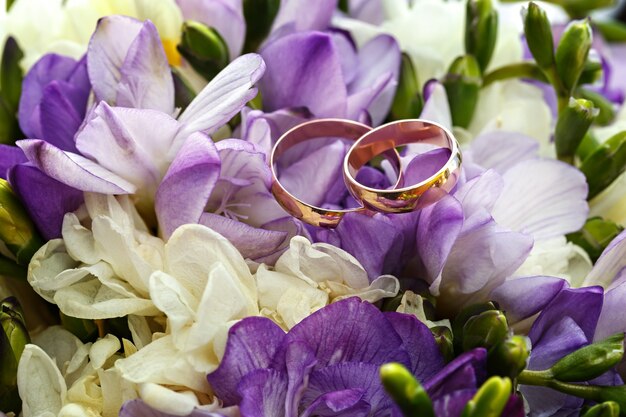 Gold wedding rings on a bouquet of flowers for the bride