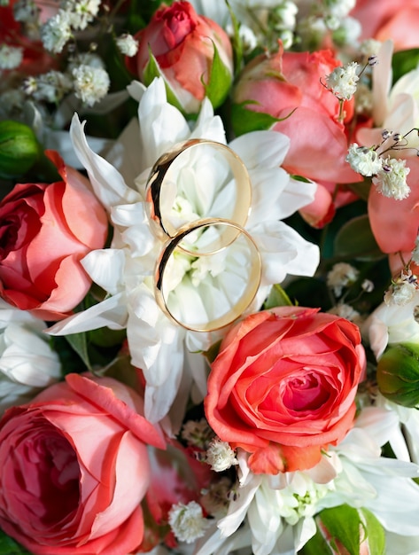 Gold wedding rings on a bouquet of flowers for the bride