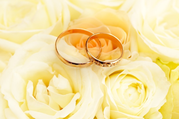 Photo gold wedding rings on a bouquet of flowers for the bride