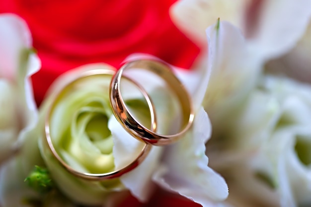 Gold wedding rings on a bouquet of flowers for the bride