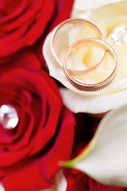 Gold wedding rings on a bouquet of flowers for the bride