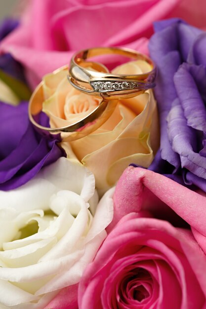 Gold wedding rings on a bouquet of flowers for the bride