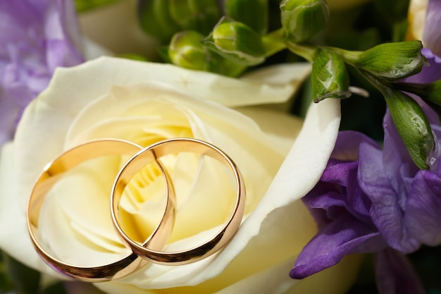 Gold wedding rings on a bouquet of flowers for the bride