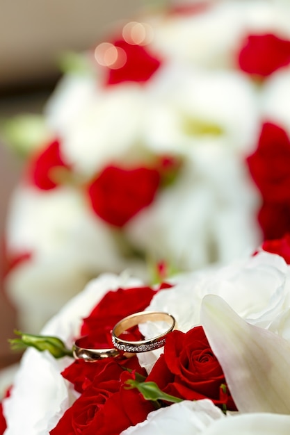 Gold wedding rings on a bouquet of flowers for the bride