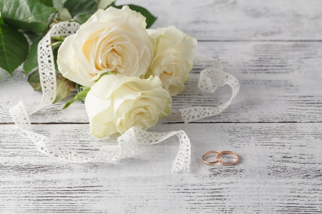 흰 장미 꽃다발에 골드 결혼 반지