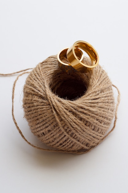 Gold wedding rings close-up on a decorative thread