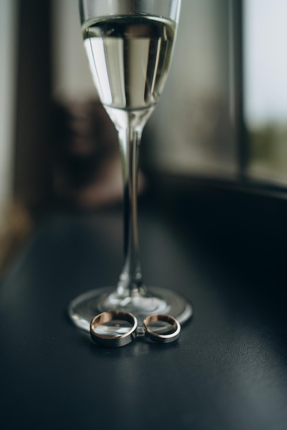 Gold wedding rings in a a glass of champagne