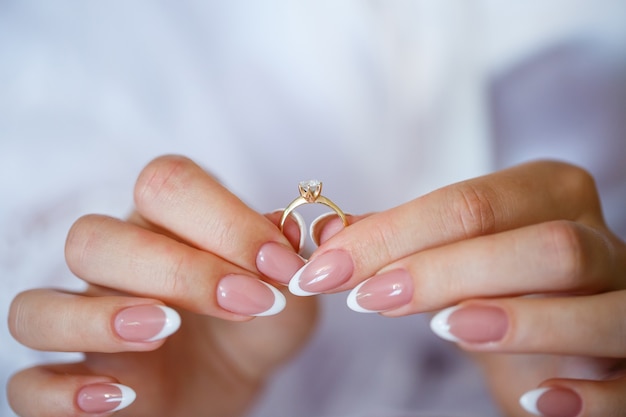 Золотые обручальные кольца в руках молодоженов в день свадьбы