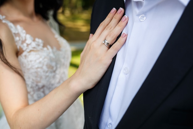 Gold wedding rings in the hands of the newlyweds