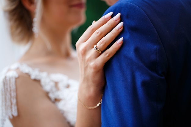 Gold wedding rings in the hands of the newlyweds