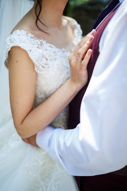 Gold wedding rings in the hands of the newlyweds