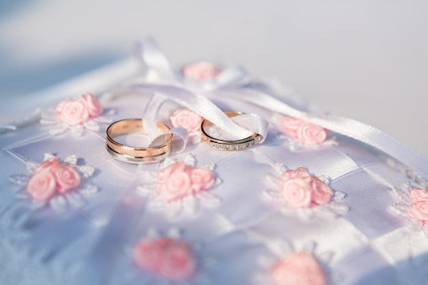 gold wedding rings on the white pincushion