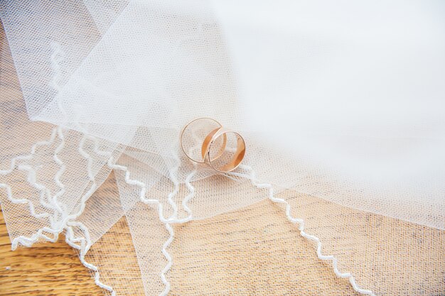 Gold wedding rings on white veil