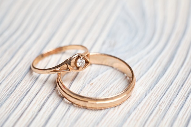 Gold wedding rings on a wooden space.