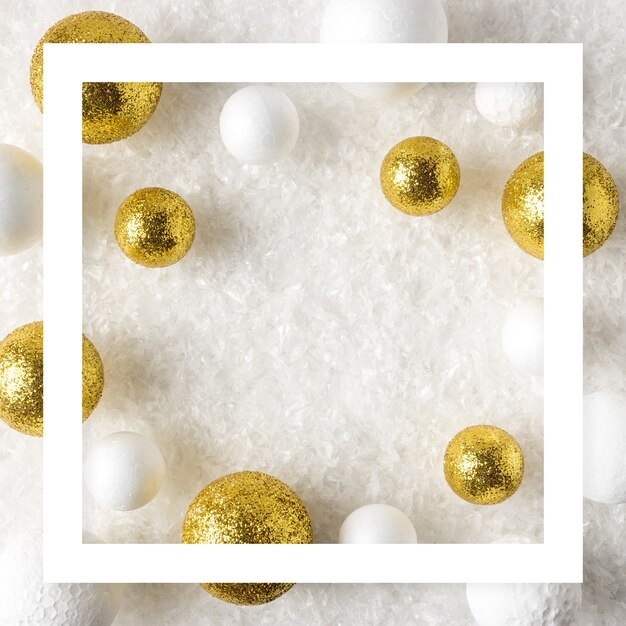 Gold and white glitter ball decorations in the snow