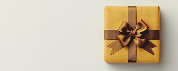 Gold wrapped gift box with a bow on a light background