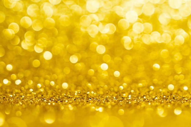 Золото, желтый абстрактный светлый фон, золотые сияющие огни, сверкающие сверкающие рождественские огни. Размытый фон абстрактный праздник.