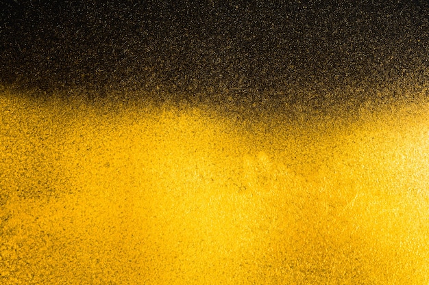 Golden abstract grainy texture on black background