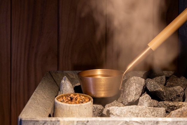 Photo golden adle for pouring water on hot stones in the sauna and steam