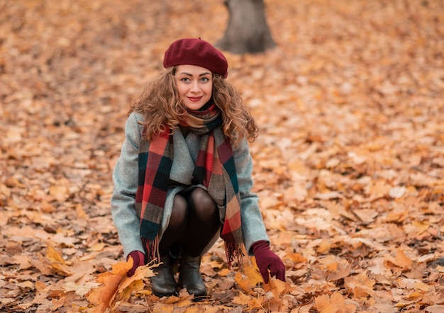 Golden autumn, model posing for a photographer, brunette walks in the park.