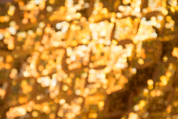デフォーカスされた抽象的な光の黄金の背景。ゴールデンボケライト。