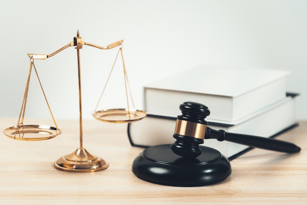 법률 사무소 평등의 책이 있는 책상 위의 황금색 균형 저울 및 의사봉