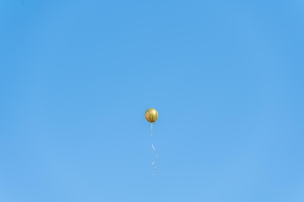 A golden balloon flew under the blue sky and white clouds