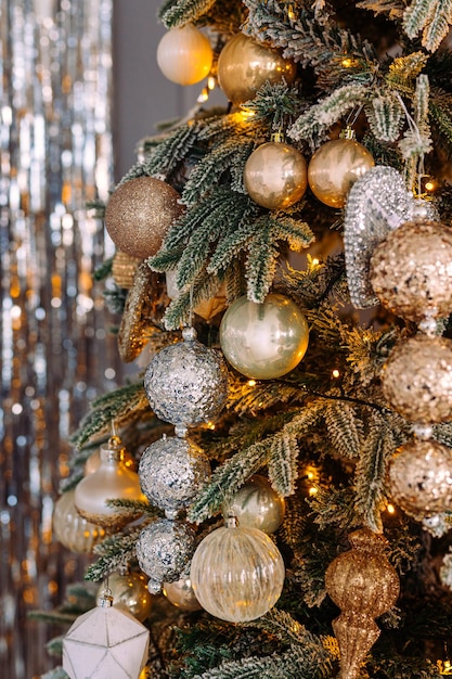 Golden balls decorated with sequins on the Christmas tree close-up