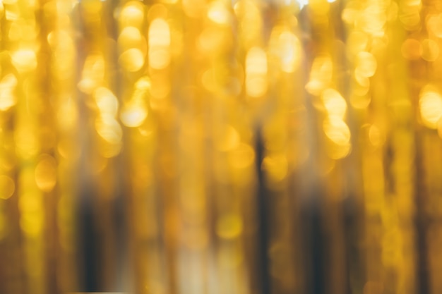 Golden beautiful blurred bokeh background with copy space. Holiday texture. Wallpaper. Glitter light spots on golden background, defocused