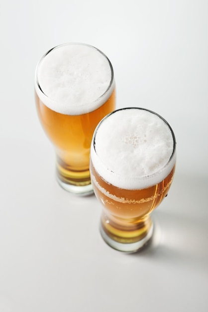 Golden beer lager ale with foam poured into glasses