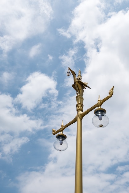 Golden bird sculpture on the top of eletrical lamp.